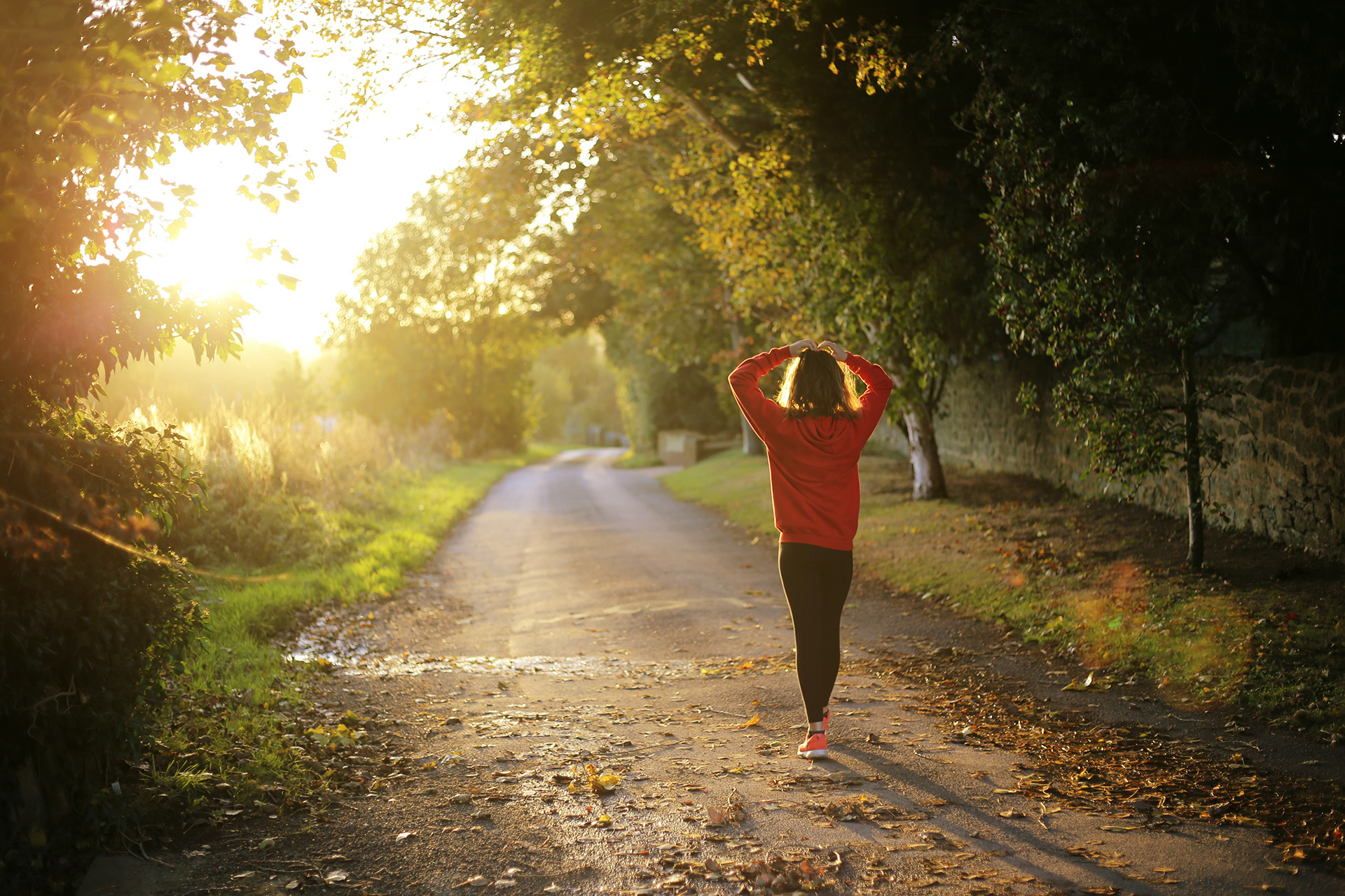 a woman walks on an outdoor trail representing the physical health domain