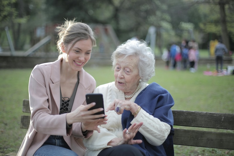 a young woman and an elderly woman talk animatedly illustrating social connectivity