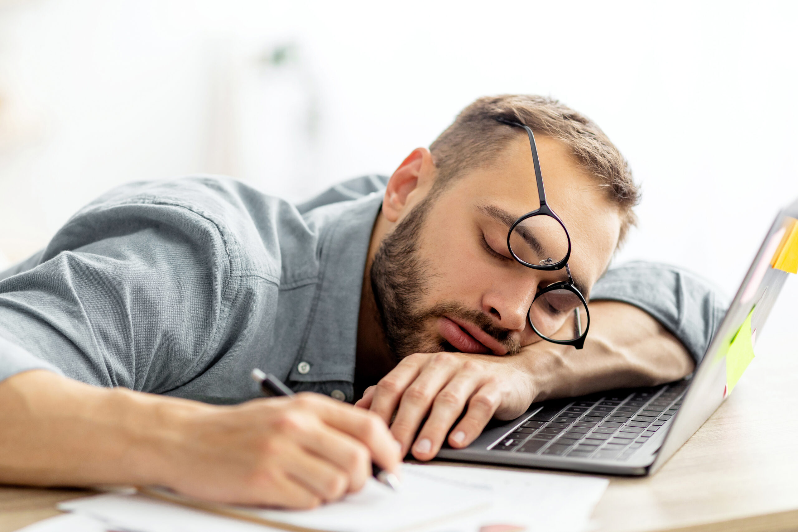 a tired man asleep at his computer