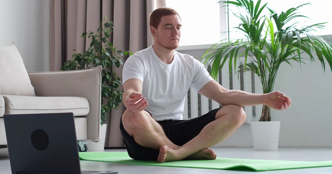 a man meditating on a yoga mat for stress management