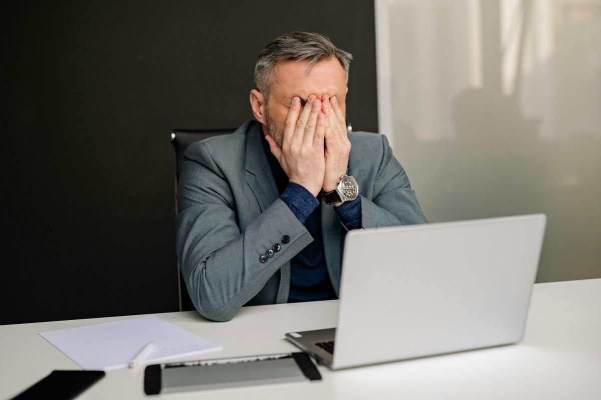overcome default stress responses Rozanski a businessman puts his hands over his face in an example of a stress coping method
