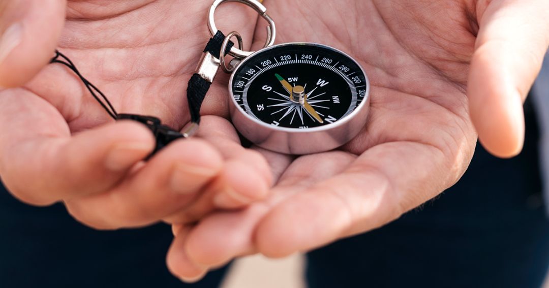 tuning fork life example header hands holding a compass, a metaphor for finding life's path