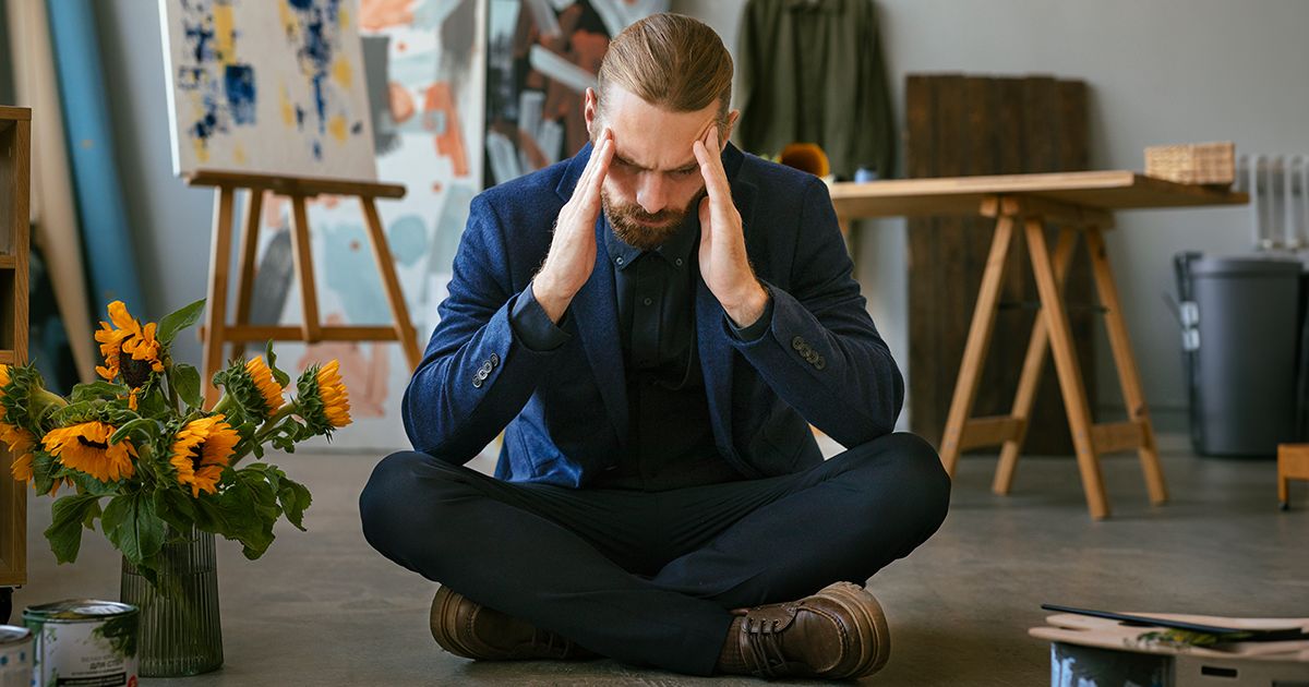 Mental Clutter HERO figure a man with his hands on his temples, overwhelmed by mental clutter